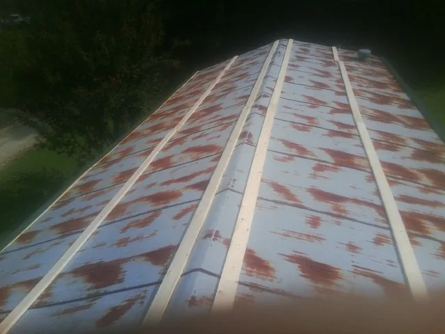 Rusted metal roof panels with new wood purlins before replacement — Storm Damage Roof Repair in Yadkinville by Roofing Brothers