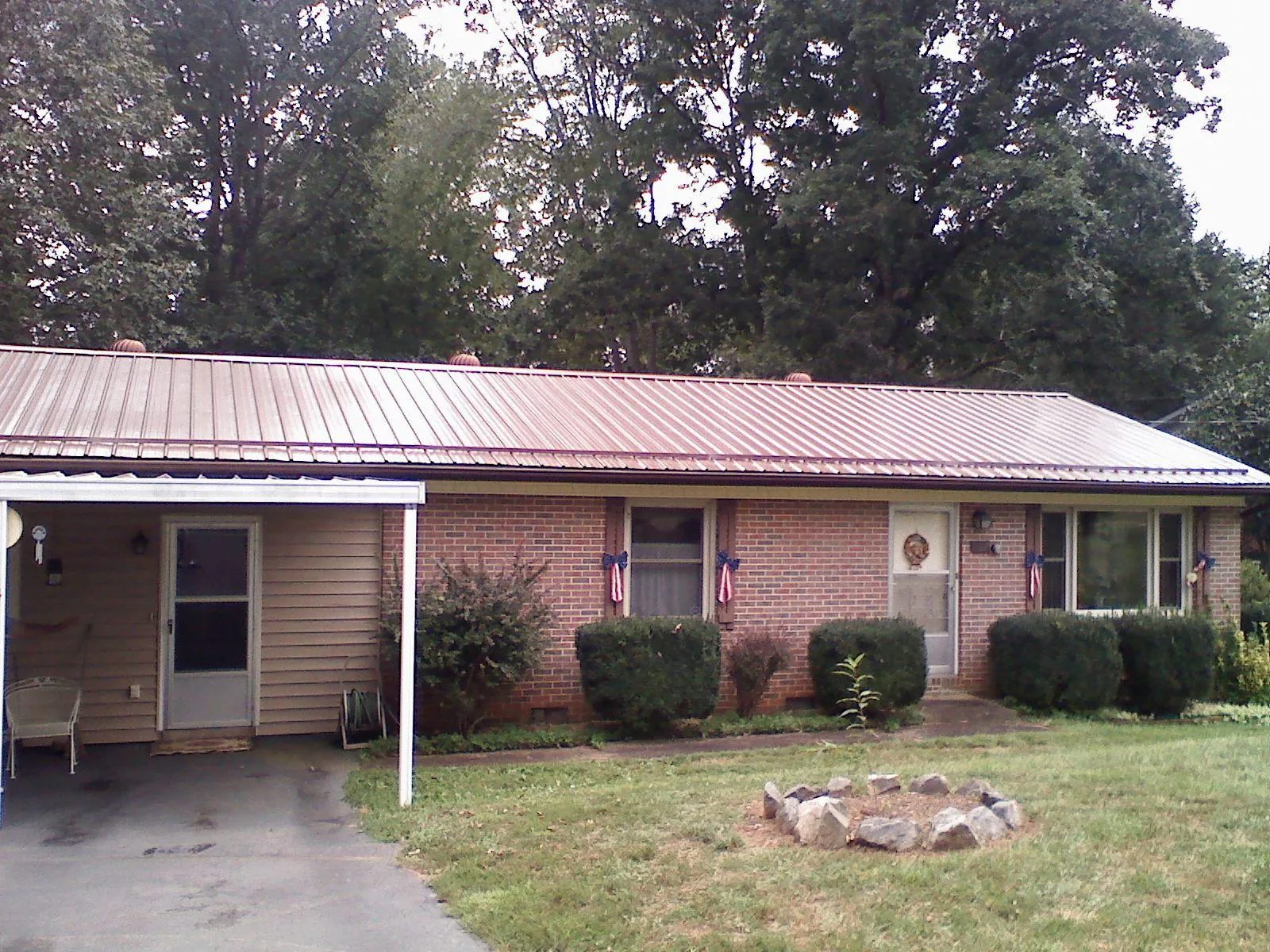 Bronze metal roof and carport on a brick ranch home — Roof Repair work by our crew in Yadkinville