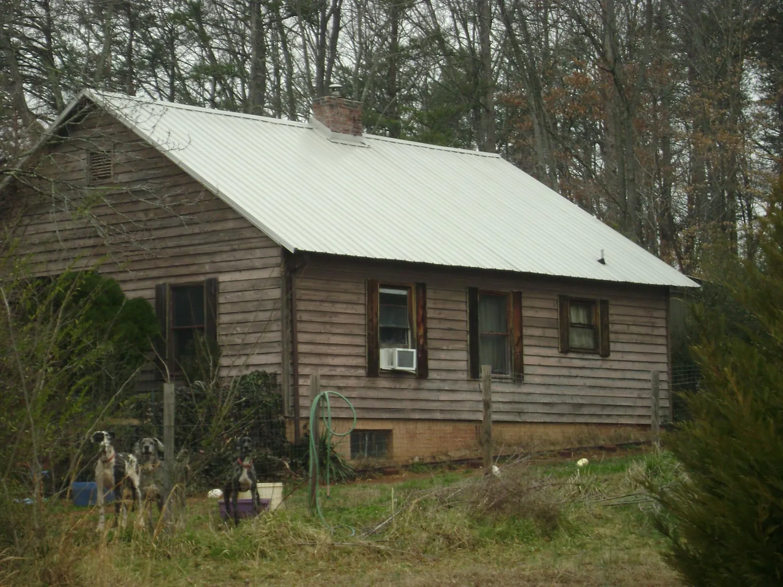 White metal roof on an old wood sided farmhouse, from a Metal Roof Installation job in Yadkinville